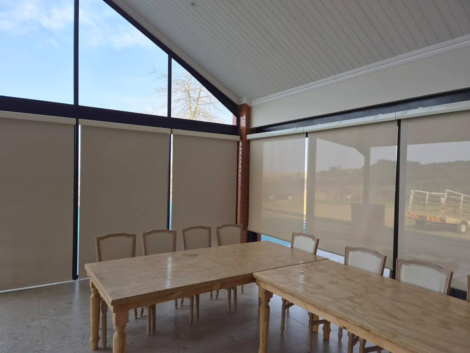 Sunscreen roller blinds fitted in a vaulted glass dining and function room