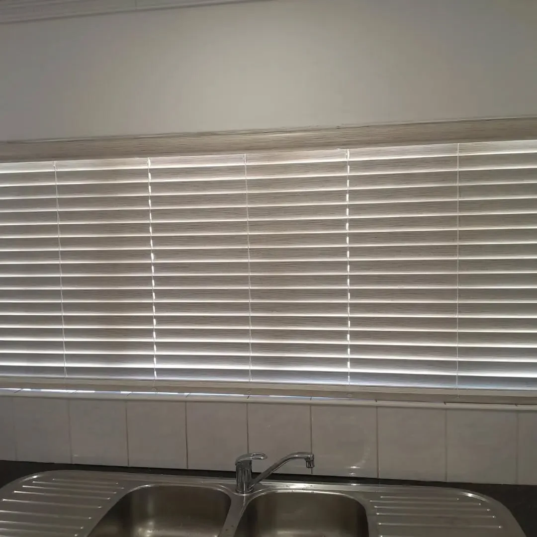 Timber-look venetian blinds fitted above a kitchen sink window